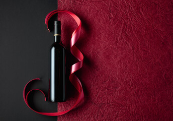 Bottle of red wine with red and pink satin ribbons.
