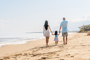 Fototapeta na wymiar A family together walking on the beach.