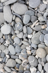 Stones on a shingle beach rounded and polished by coastal sea erosion, flat lay. New Zealand 