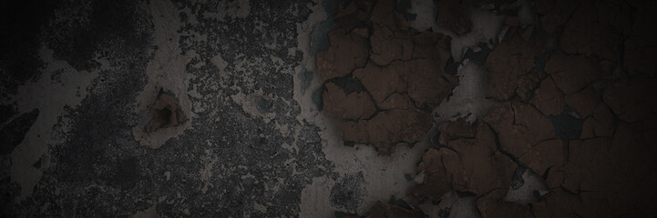 Dark wide panoramic background. Peeling paint on a concrete wall. Dark grunge texture of old cracked flaking paint. Weathered rough painted surface. Patterns of cracks. Darkness background for design.