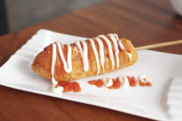 Korean corn dog or Korean hot dog is a popular street food made of sausages or mozzarella cheese on sticks and wrapped with yeasted batter and coated with breadcrumbs then deep fried to golden.