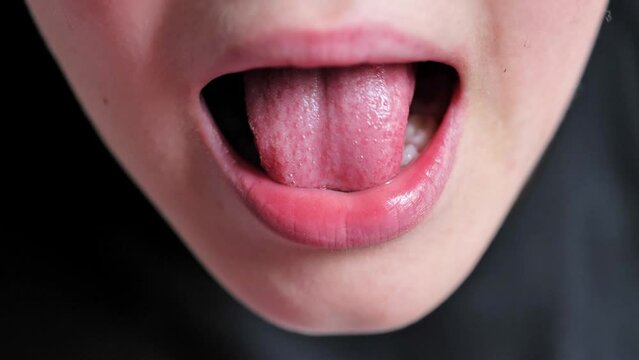 boy touches a crooked milk tooth. Kid lost a tooth. Close up of tooth that falls macro