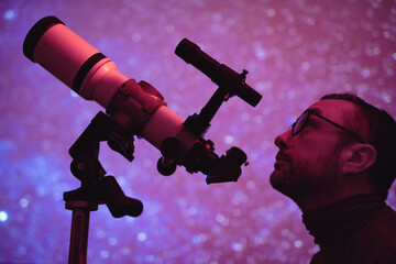 Astronomer looking at the starry skies with a telescope.