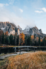 Autumn colours of Lake Lago d'Antorno and bridge in Dolomites Italy