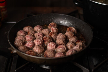 Meatballs in a frying pan. Making meatballs. Dark background.