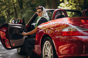 Beautiful woman driving red cabrio