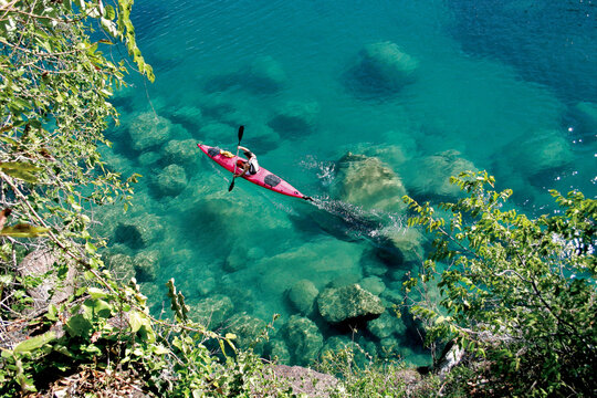 Kayakers exploring the beautiful waters and beautiful rock formations of Lake Malawi near Mumbo Island.