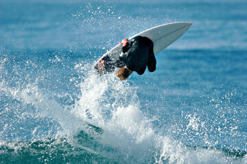 Fototapeta premium A surfer executes a radical aerial move as he surfs a wave in the ocean.