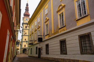 A quiet backstreet in Klagenfurt am Worthersee, Carinthia, Austria. The street is  Pfarrhofgasse street, and the 17th century Pfarrkirche Klagenfurt St Egid church can be seen at the end of the street