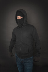 Unrecognizable man in the black hoody with hood wearing balaclava mask