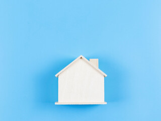 flat lay of wooden model house on blue background.