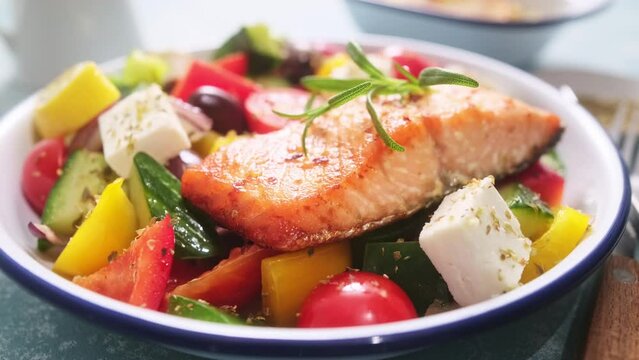 Greek salad and grilled salmon fish in bowl. Traditional mediterranean cuisine Choriatiki salad. Healthy food, diet. Stock video 4k