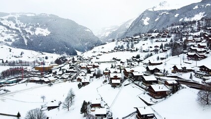 Fototapeta na wymiar Grindelwald village in Switzerland aerial drone video on snowy day in winter time
