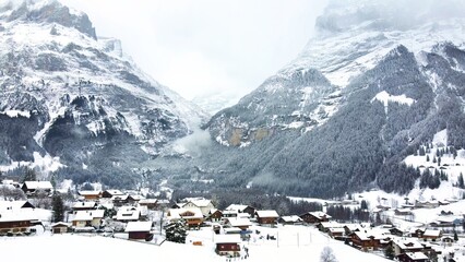 Grindelwald village in Switzerland aerial drone video on snowy day in winter time