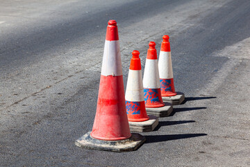Traffic cones stand in a row on an asphalt road. Devices for temporary marking of roads. Avriynye...