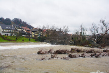 The Hudiceva Brv Bridge, the Devil's Footbridge, as it crosses over Poljanska Sora river in Skofja Loka in Gorenjska, Slovenia. The river is very full due to recent heavy rain
