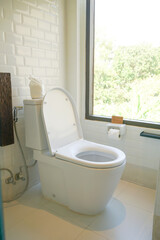white toilet in restroom with window