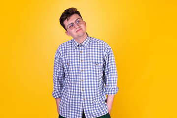 Fototapeta premium A handsome guy in glasses on a yellow background