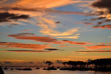 A view of a beautiful orange sunset over a bay.