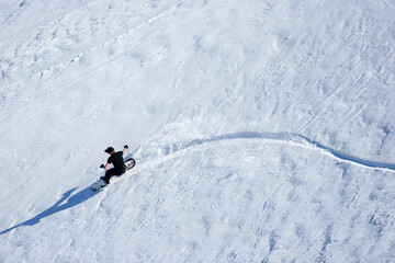 A snowboarder carves down a snow-covered slope as he goes off piste in the Maluti Mountain in...