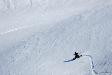 A snowboarder carves down a snow-covered slope as he goes off piste in the Maluti Mountain in Lesotho, Africa.