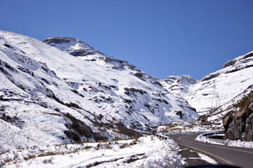 A road winds up a pass through a mountainous landscape in the Kingdom of Lesotho, Africa.