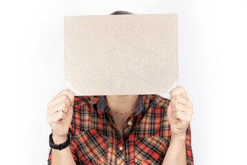 A woman in simple work clothes holds a cardboard sign in front of her with space for text, her face is covered, a woman is looking for a new better job