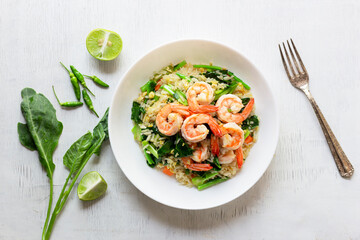 Fried rice with shrimp has vegetable in plate on white table.