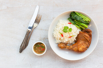 Healthy food chicken braised has rice kale garlic chili sauce in plate on white wood table.