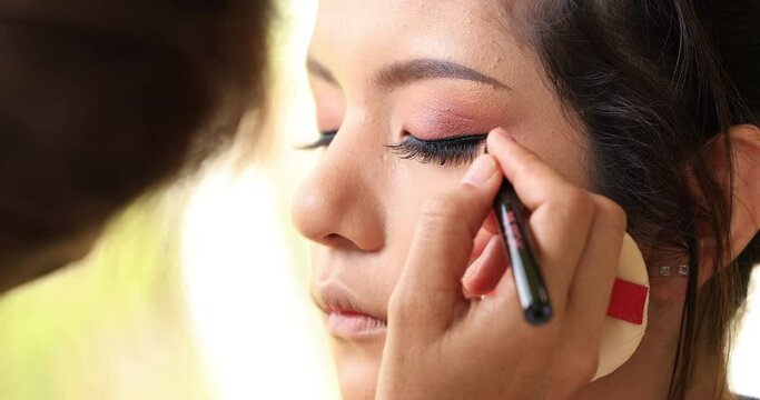 make-up, artist paint the eyelids on the eyes with a makeup eyebrow pencil.4k video
