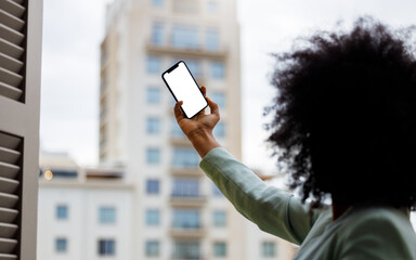 Afro American woman using a smartphone with a white screen for mock up design. Business woman taking a selfie with mock-up screen
