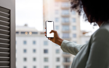 Afro american woman using a smartphone with white screen for mock up design.