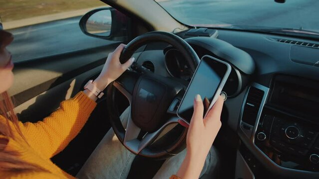 Young woman driver using mobile phone while driving car in motion, distracted driving, don't text and drive - Powered by Adobe