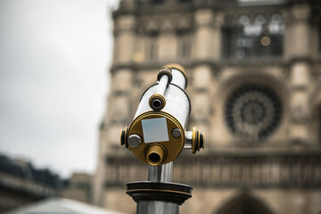 Telescope. City spyglass. Telescope overlooking Notre Dame. View point with telescope on the Notre Dame.