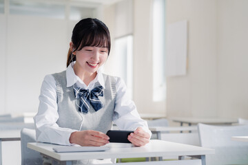 スマホで動画を視聴する女子高生