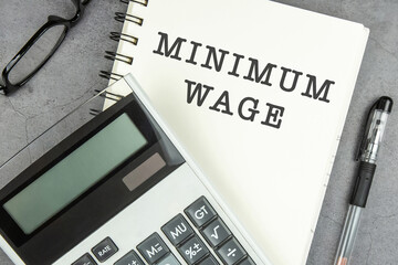 Minimum wage text on note pad with calculator.
