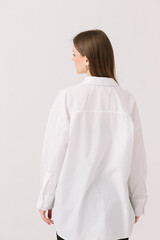 Photo of a pretty woman in a white shirt isolated on a white background. Shirt mockup.