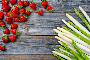 Reife rote Erdbeeren, sowie weißer und grüner Spargel aus biologischem Anbau angeboten als...