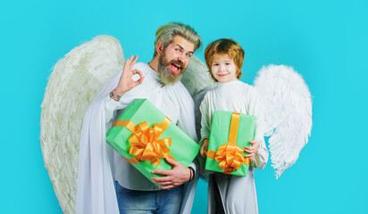 Little angel child with gift and bearded man in angelic wings shows sign ok. Valentine day shopping.