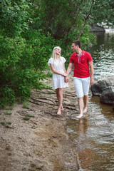 couple in love blonde girl and guy on the river bank