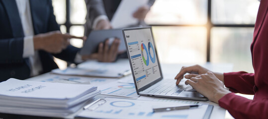 Business People Meeting using laptop computer,calculator,notebook,stock market chart paper for analysis Plans to improve quality next month. Conference Discussion Corporate Concept..