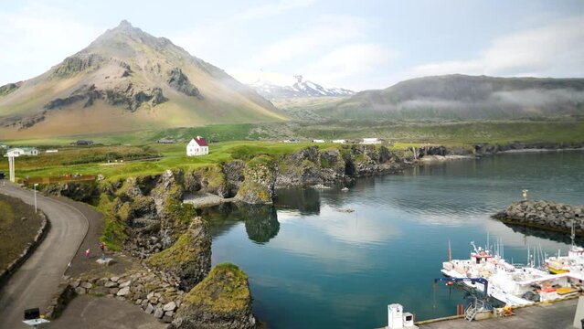 Arnarstapi village in Iceland. Harbor in Arnarstapi with a small white church with huge moutains in the back. High quality 4k footage.