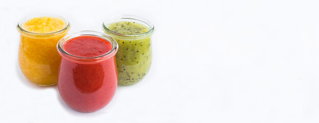 Smoothie or puree with fruit and berry in the small glass jars on the white background. Copy space. Banner.