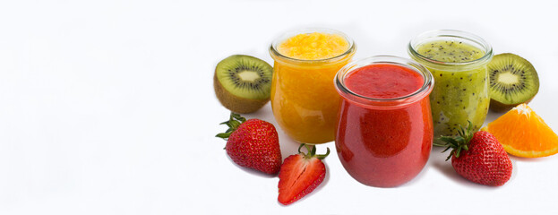 Smoothie or puree with fruit and berry in the small glass jars on the white background. Copy space. Banner.