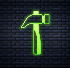 Glowing neon Hammer icon isolated on brick wall background. Tool for repair. Vector