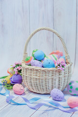 basket with painted Easter eggs on a light wooden background, Easter card. High quality photo