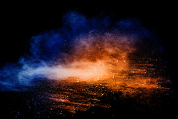 Orange blue  powder explosion on black background.Orange blue color dust splashing.