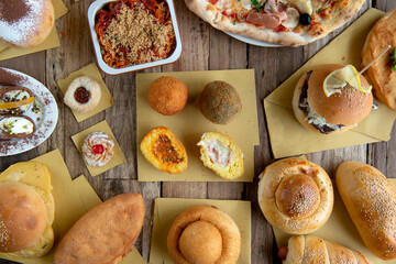 Typical food from Sicily region called arancina, pane ca emus ragazzata, sfincioni and cannoli on wooden background