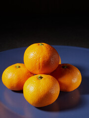 one orange mandarin on blue plate