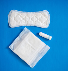 Health care and medicine tampons, pads on blue background © KseniyaK